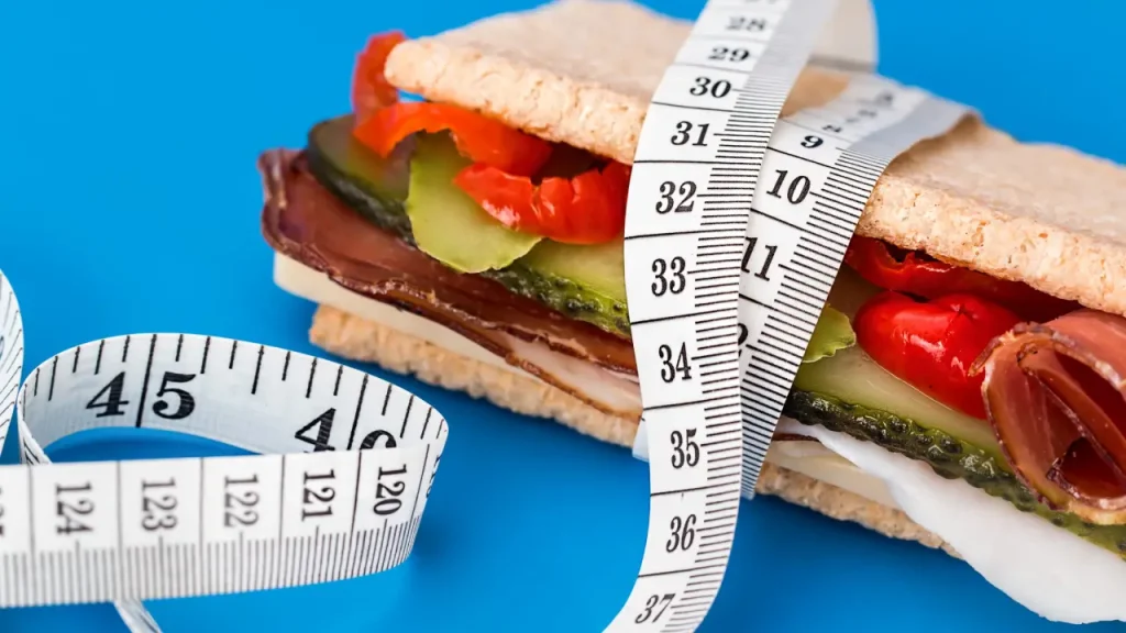 Weight Gain After Quitting Smoking - image of a tape measure with a sandwich